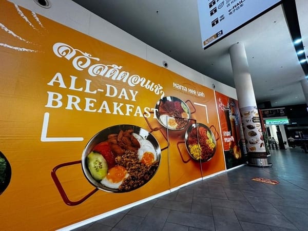A Mama Mee Yah hoarding inside an airport terminal, with the klia2 terminal sign above it.