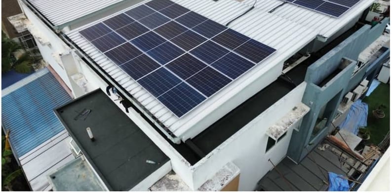 The same roof section finished in dark membrane beside the solar array.